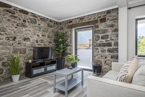 a living room with a stone wall at Basalt House A by Homie in São Vicente