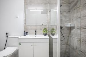 a white bathroom with a sink and a shower at Basalt House A by Homie in São Vicente +13 photos