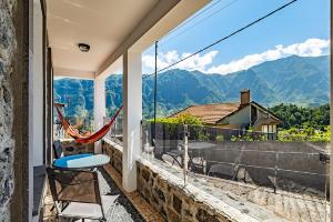 a balcony with a chair and a view of mountains at Basalt House A by Homie in São Vicente