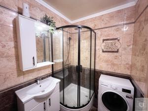 a bathroom with a shower and a washing machine at RentHouse Apartments Little Paris in Chişinău