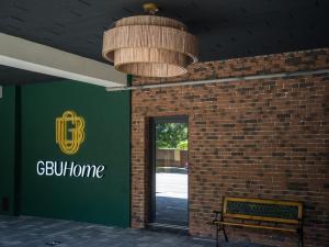 a building with a green sign and a bench at GBU Home Timisoara in Timişoara