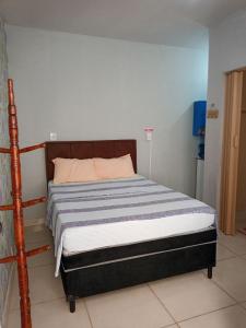 um quarto com uma cama com uma estrutura em madeira em Suite para seu descanço em Indaiatuba