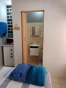 uma cozinha com um lavatório e uma cama num quarto em Suite para seu descanço em Indaiatuba