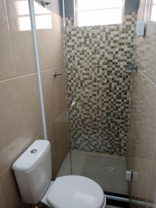uma casa de banho com um WC e uma cabina de duche em vidro. em Suite para seu descanço em Indaiatuba