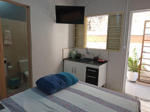 a bedroom with a bed with a blue pillow on it at Suite para seu descanço in Indaiatuba