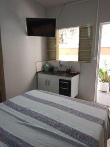 um quarto com uma cama e um lavatório em Suite para seu descanço em Indaiatuba