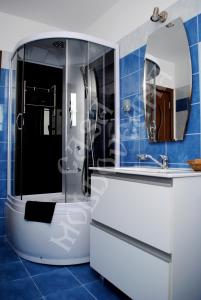 La salle de bains est pourvue d'un lavabo blanc et d'un miroir. dans l'établissement Pensiunea CASA MOLDOVEANA, à Piatra Neamţ