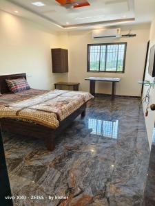 a bedroom with a bed and a table in it at POP Hotel Harsh in Aurangabad