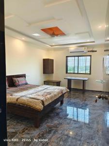 a bedroom with a bed and a table in it at POP Hotel Harsh in Aurangabad
