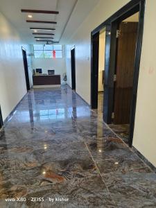 a hallway with a marble floor in a building at POP Hotel Harsh in Aurangabad