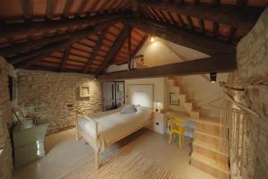 um quarto com uma cama e uma escada num edifício em Country old stone house immerse in nature em Lequio Berria
