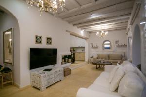 uma sala de estar com um sofá branco e uma televisão de ecrã plano em Villa Surfland em Ftelia
