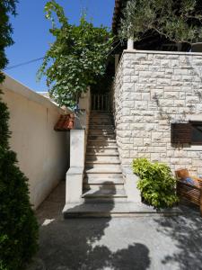 uma escada que conduz a um edifício com uma parede de pedra em Villa Rošin with Garden&Pool em Milna
