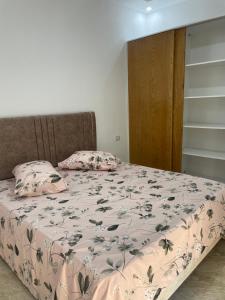 - une chambre dotée d'un lit avec une couverture et des oreillers dans l'établissement Deluxe apartment, à Kelibia