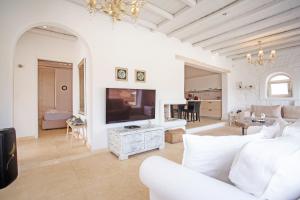 a living room with a white couch and a tv at Villa Surfland in Elia