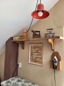 uma lâmpada vermelha pendurada numa parede com uma prateleira em Pousada Jangadeiro em Porto Seguro