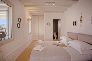 - une chambre blanche avec un lit et des serviettes dans l'établissement Villa Surfland, à Ftelia
