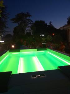 a swimming pool with green lighting at night at Il Sogno delle Rondini in Palidoro