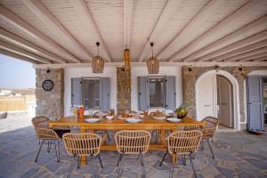a large wooden table and chairs on a patio at Villa Surfland in Elia