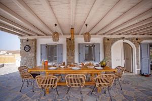 una gran mesa de madera y sillas en un patio en Villa Surfland, en Ftelia