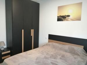 een slaapkamer met een bed en een zwarte kast bij Apartman Sterpin in Pula
