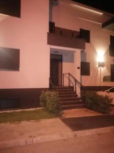 een gebouw met een trap die 's nachts naar een deur leidt bij Apartman Sterpin in Pula