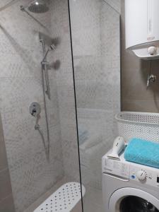 a bathroom with a shower and a washing machine at K2-SistersApartment in Podgorica