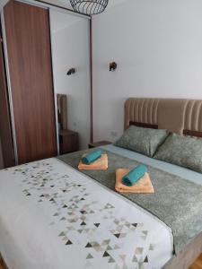 a bedroom with a bed with two towels on it at K2-SistersApartment in Podgorica