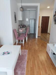 uma sala de estar com mesa e cadeiras e uma cozinha em K2-SistersApartment em Podgorica