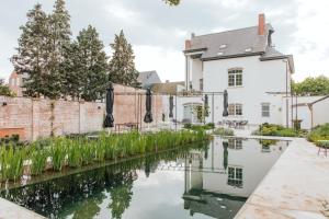 una casa con un canal frente a ella en Visite en Evergem