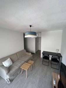 una sala de estar con un sofá y una mesa en Appartement cosy au cœur de Sète avec balcon détente, en Sète
