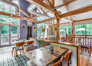 a restaurant with wooden tables and chairs and windows at Bath Mill Lodge Retreat in Bath