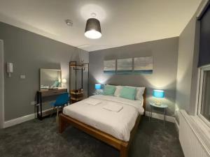 a bedroom with a bed and a desk with two lamps at Small Double Studio close to King's Cross & Camden in London