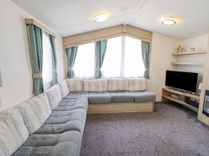 a living room with a couch and a large window at 14 Larch View in Lincoln