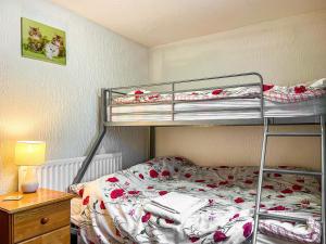 a bedroom with two bunk beds and a lamp at The Corn Store - Uk44693 in Cheadle