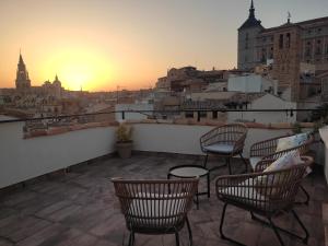 un patio en la azotea con sillas y vistas a la ciudad en La Casa Toledana - patio y terraza con vistas, en Toledo
