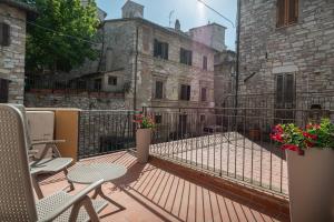 einen Balkon mit Stühlen und Tischen sowie ein Gebäude in der Unterkunft Xenios Assisi in Assisi