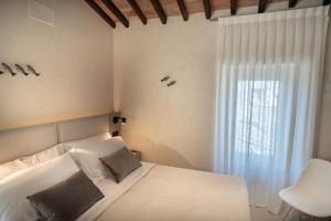 una camera con un letto bianco e una finestra di Xenios Assisi ad Assisi