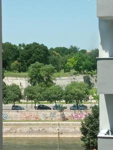 een uitzicht op een park met auto's geparkeerd op een parkeerplaats bij Riviera Apartments in Niš