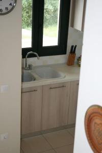 a bathroom with a sink and a window at elgevacation villa 1 in Lagomandra