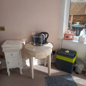 una pequeña mesa con una tetera encima en Beautiful self-contained annex/Cottage, en Hoylake