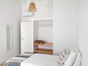 um quarto com paredes brancas e uma cama com almofadas em Terreiro Ocean House - Sea View em São Roque