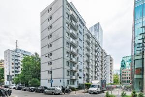 a tall gray building with cars parked in a city at Apartamenty Pańska by Your Freedom in Warsaw