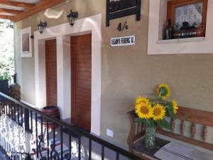 a vase filled with sunflowers sitting on a porch at Hungária Vendégház in Eger