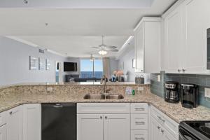 a kitchen with white cabinets and a sink at Tidewater Beach Resort 2505 - Sea Gem in Panama City Beach