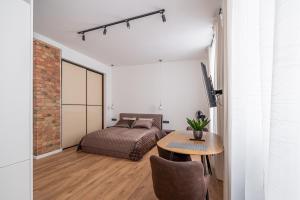 a bedroom with a bed and a table in a room at Old town studio on Mucenieku street in Riga