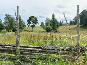 a wooden fence in the middle of a field at Vimmerby Stugby in Vimmerby