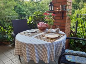 uma mesa com uma toalha de mesa azul e branca numa varanda em Hungária Vendégház em Eger
