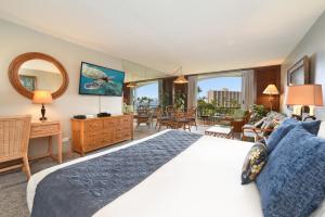 a bedroom with a large bed and a living room at Maui KaanapaliVilla A517 in Lahaina