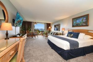 a bedroom with a large bed and a living room at Maui KaanapaliVilla A517 in Lahaina
